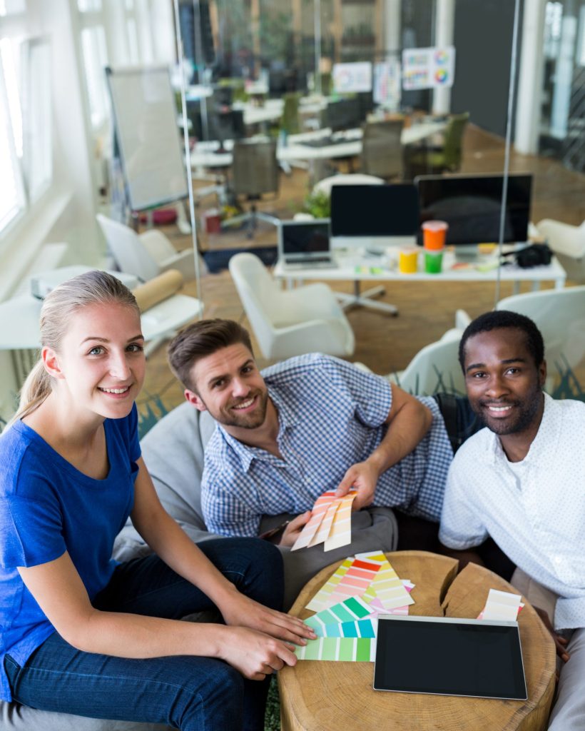 Group of graphic designers smiling and sitting together in office